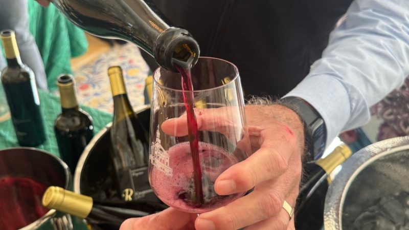 A glass of red wine being poured