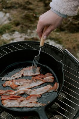 Bacon cooks in a cast iron pan