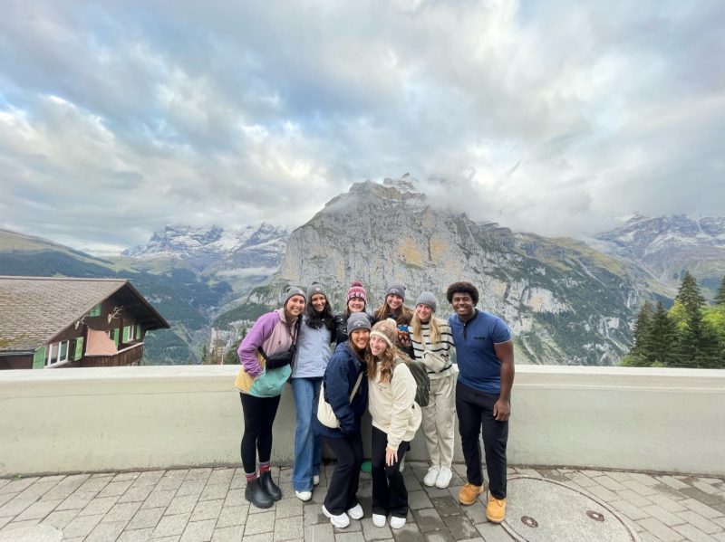 group of students on bridge with mountains behind them
