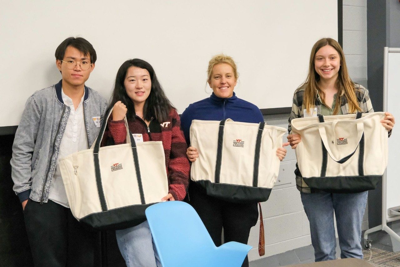 A group poses with their tote bags.