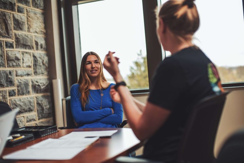 Two people talk sitting at a table