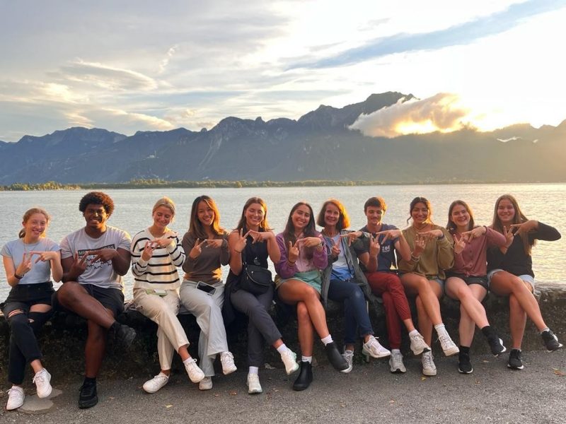 group of students sitting near lake in Italy