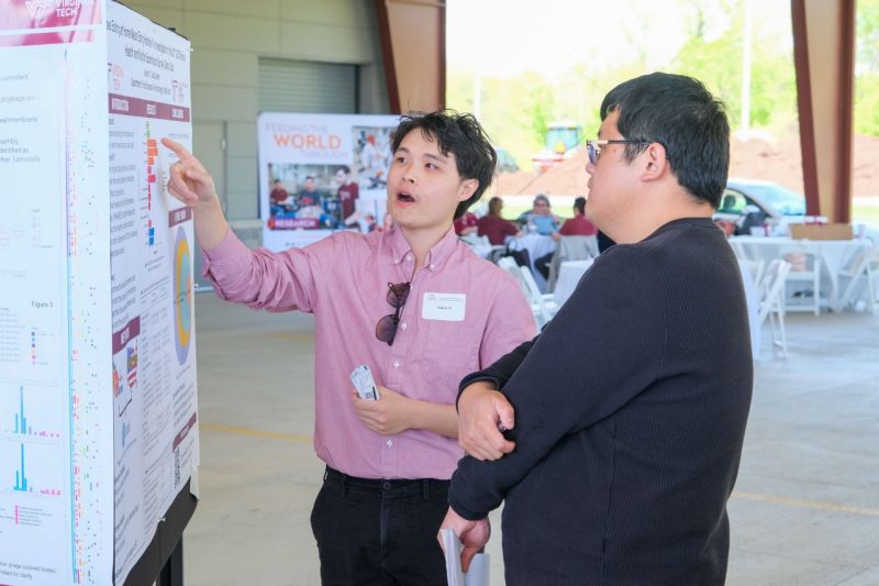 A student presents their research during a poster showcase