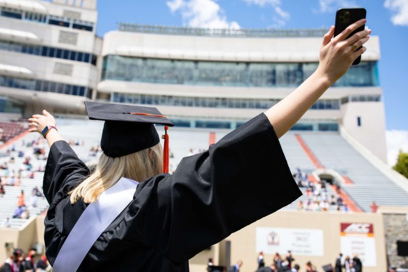 A Hokie puts up their hands during graduation.