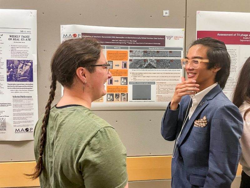 Two people talk during a research poster showing