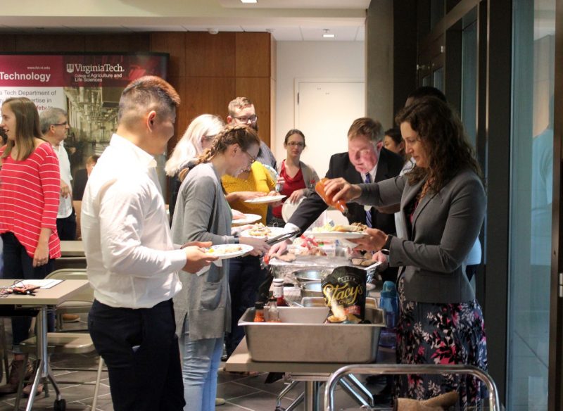 FST students, faculty and staff fill their plates with barbecue prepared by Marcy for the gathering.